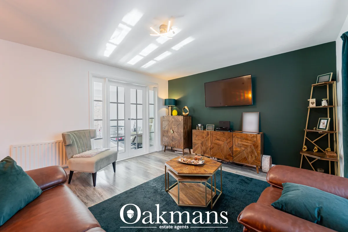 Contemporary living room with teal accent wall, cognac leather sofa, mid-century furniture, wooden coffee table, wall-mo