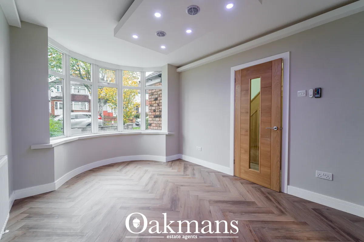 Modern hallway with bay windows, herringbone wood flooring, lavender walls, recessed ceiling lights, wooden doors with g