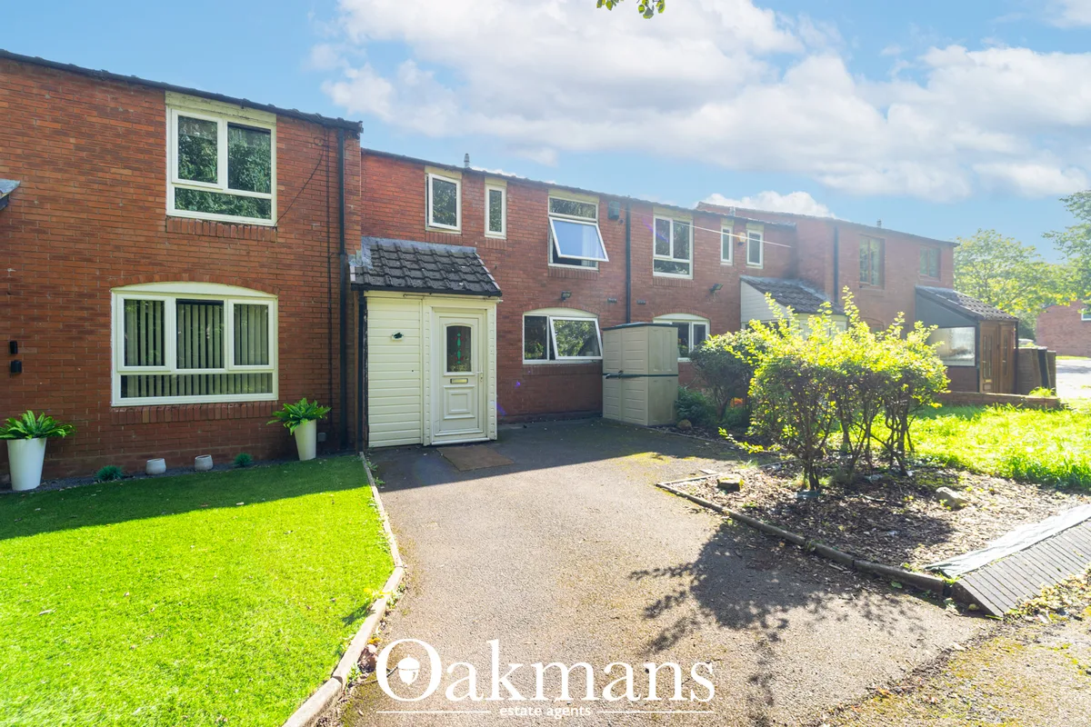 Red brick semi-detached house with white-framed bay window, garage, driveway and manicured front lawn