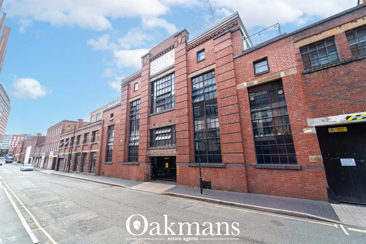 Victorian red-brick industrial building with large gridded windows, metal loading doors and period architectural detaili