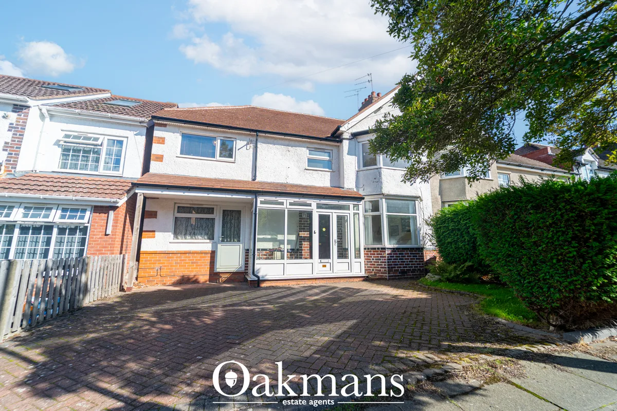 Semi-detached house with white render and brick lower section, pitched tile roof, brick driveway, modern conservatory ex