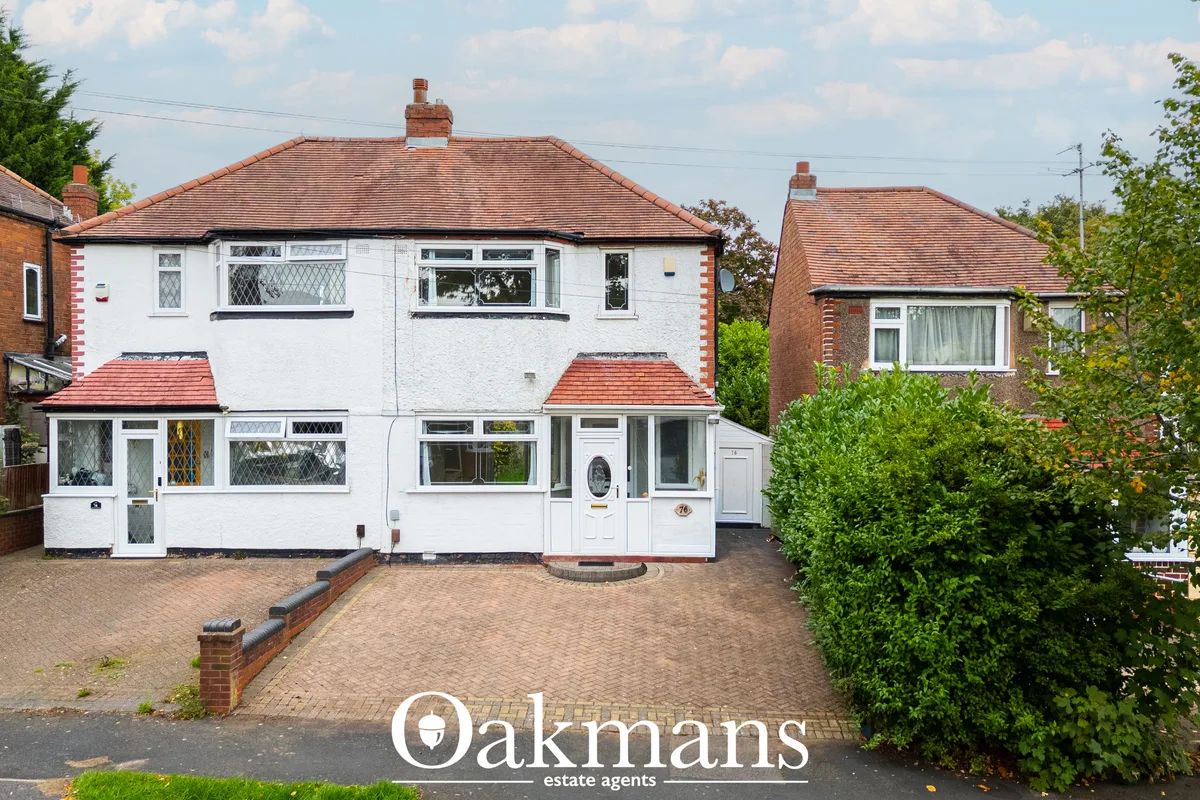 Two-storey white semi-detached house with brick chimney, terracotta roof tiles, front porch extension, brick driveway an