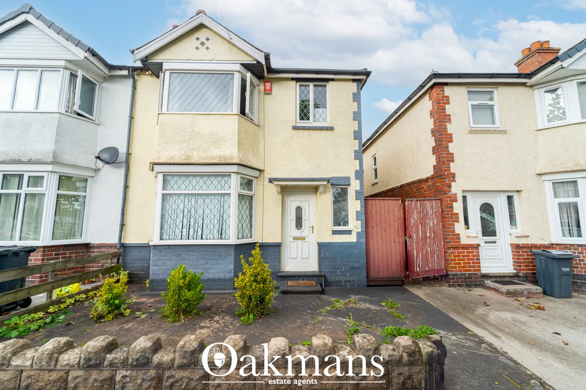 Cream and blue rendered semi-detached house with lattice windows, small front garden with shrubs, and driveway access