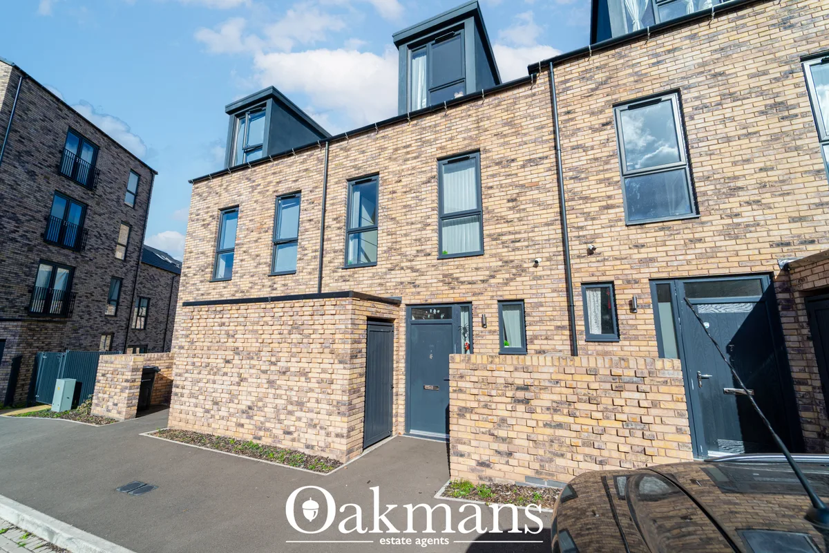 Modern brick-built residential building with pitched roof, dormer windows, and contemporary styling. Ground floor entran