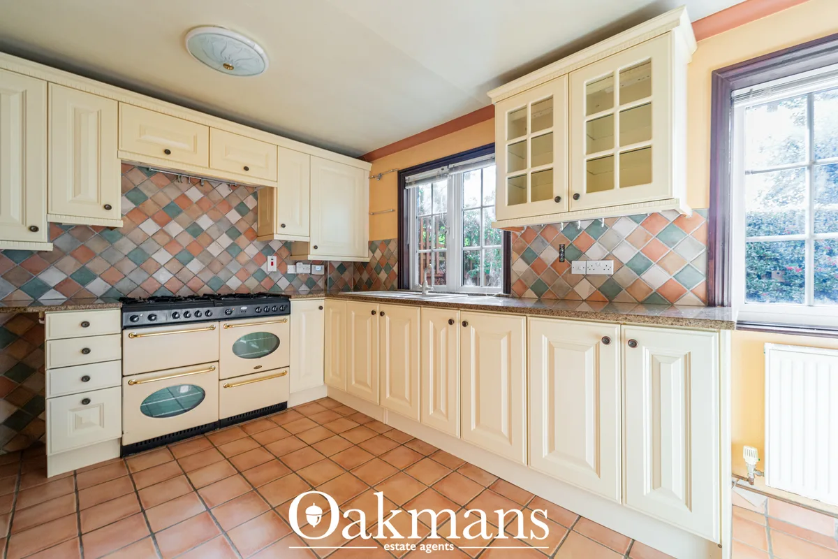 Spacious kitchen with cream cabinetry, dual range cooker, diamond-patterned tile splashback, granite worktops and large 