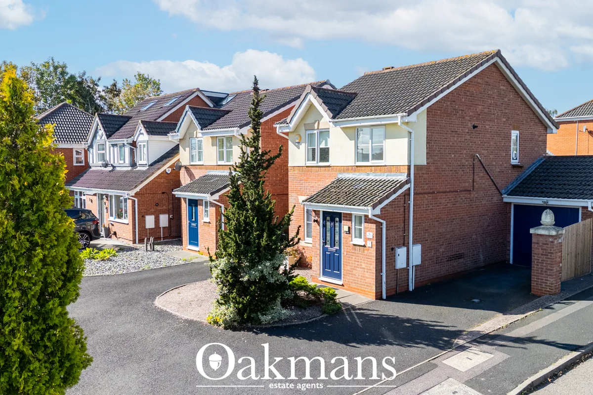 Street view of modern brick-built residential properties with driveways, manicured gardens and contemporary architecture