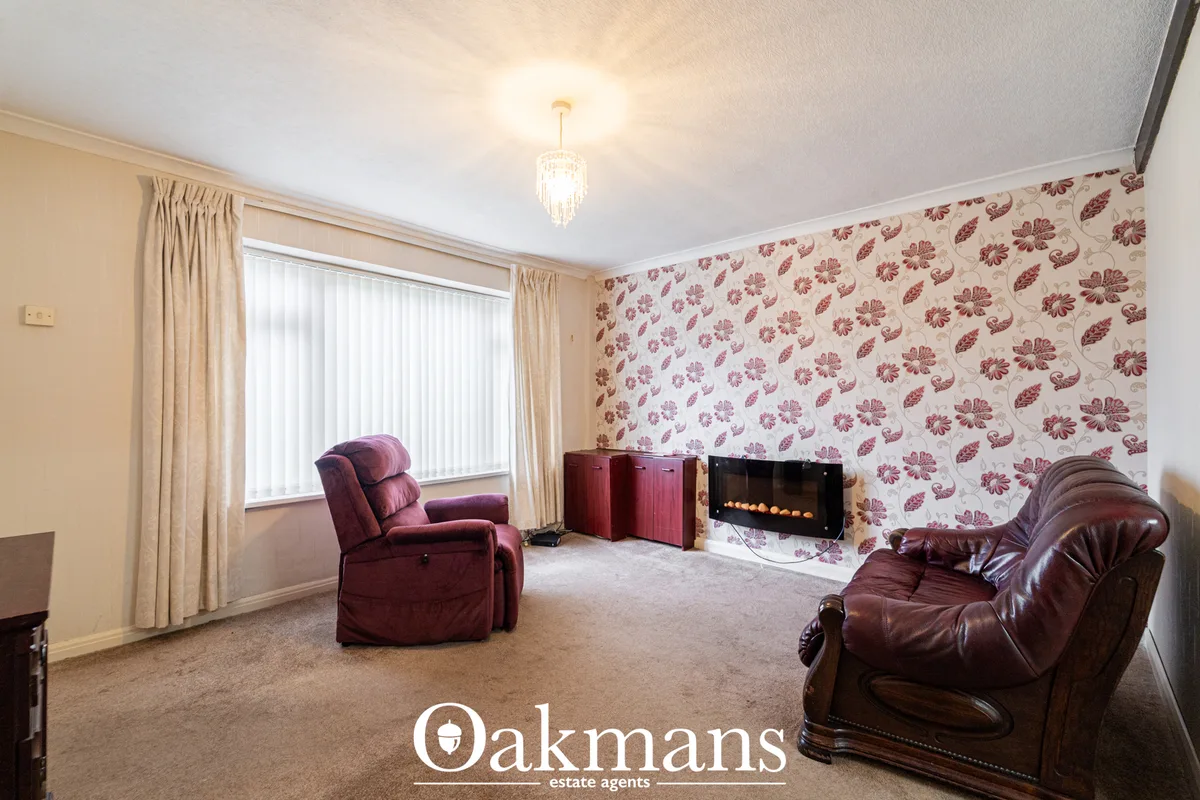 Spacious living room with burgundy leather recliners, floral wallpaper, electric fireplace, large window with cream curt