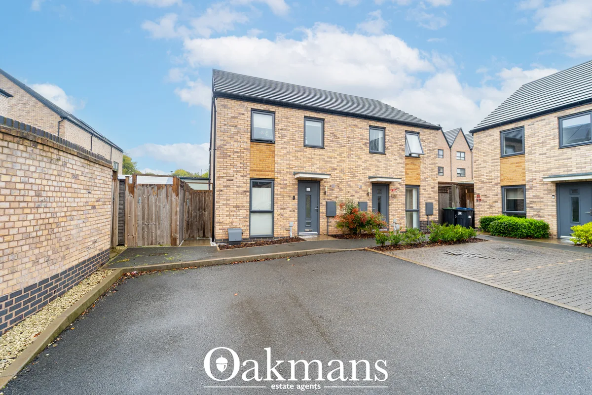 Modern brick townhouses with slate roofs, driveway and landscaped gardens in a residential development