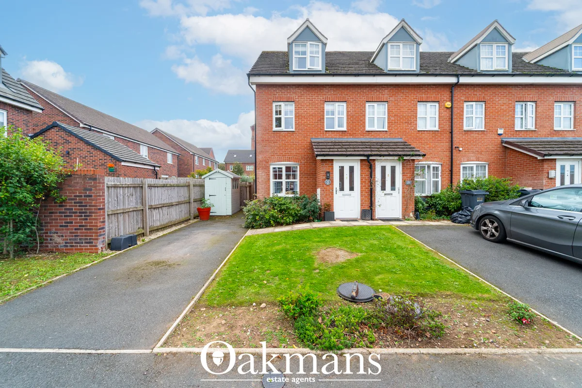 Red brick semi-detached house with white-framed windows, dormer windows, driveway, front lawn and parked car