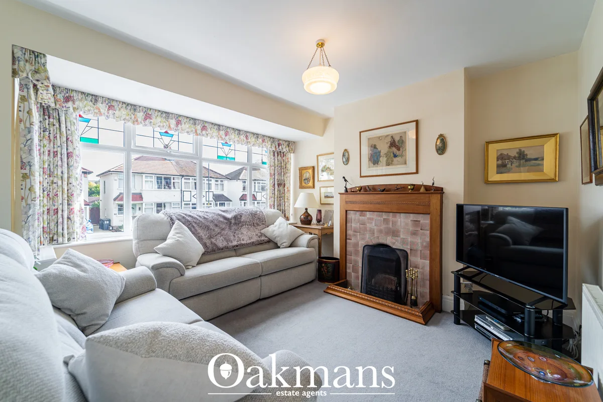 Spacious living room with grey corner sofa, fireplace with terracotta surround, flat-screen TV, framed artwork, large ba