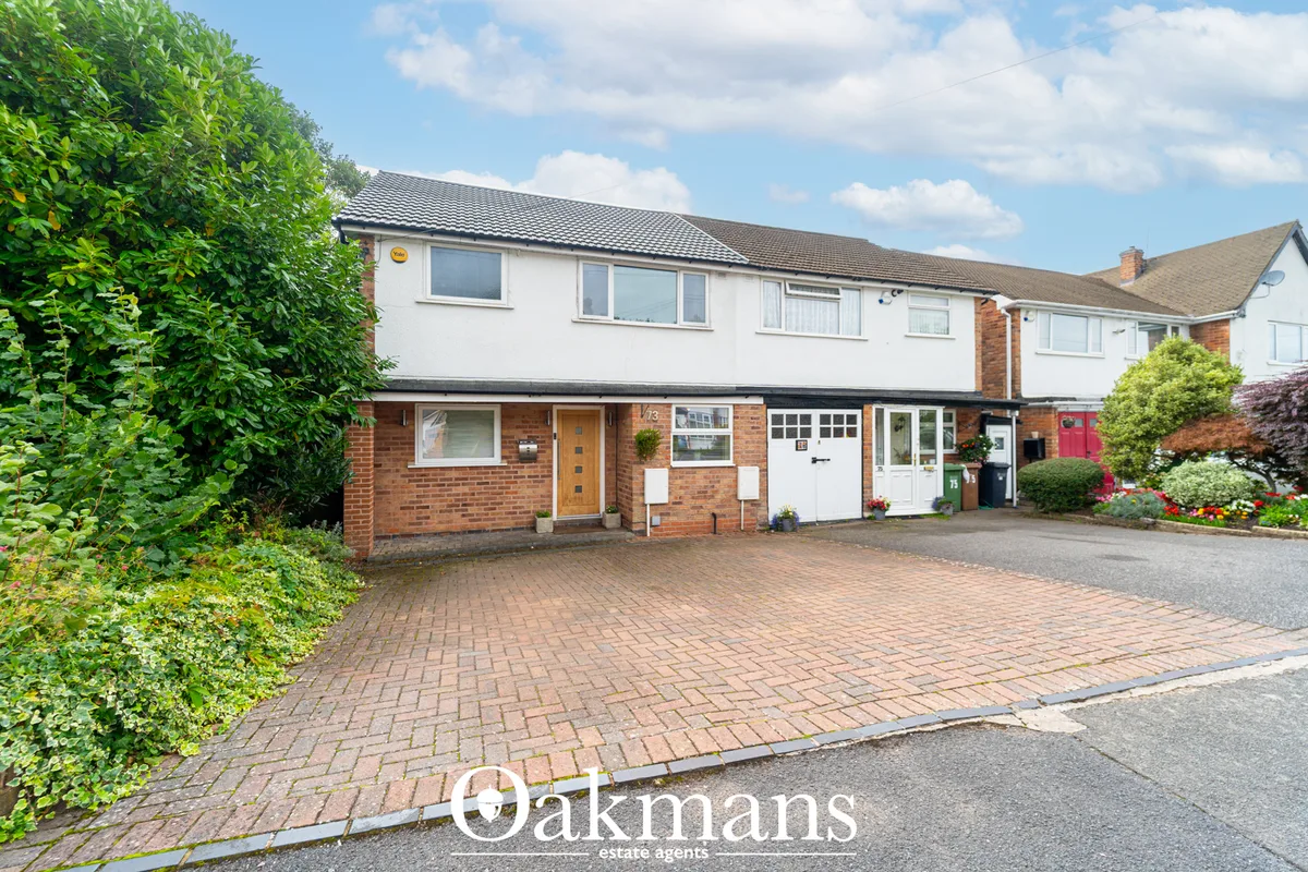 Two-storey detached house with brick lower level, white render upper, dark roof, brick driveway, mature hedging and plan