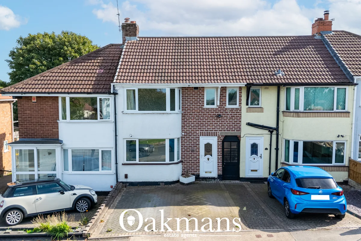 Semi-detached brick and rendered house with tiled roof, bay windows, driveway with two parked cars, and neighbouring pro
