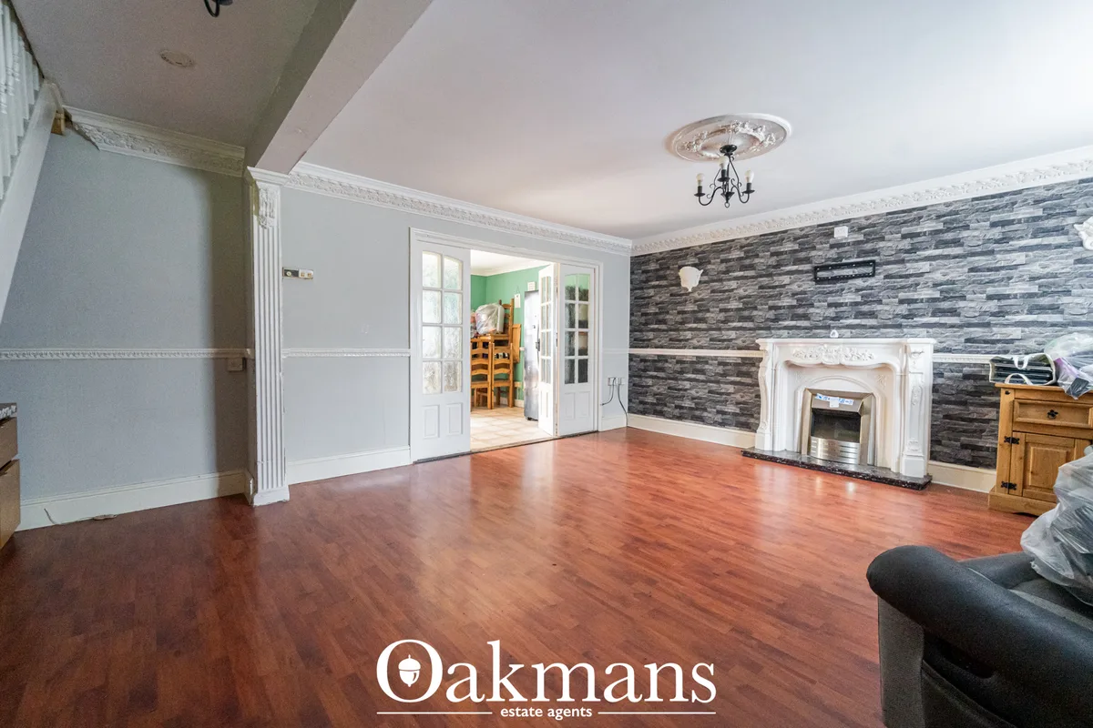 Spacious living room with wooden flooring, feature fireplace with grey stone accent wall, white ceiling cornice, and dou
