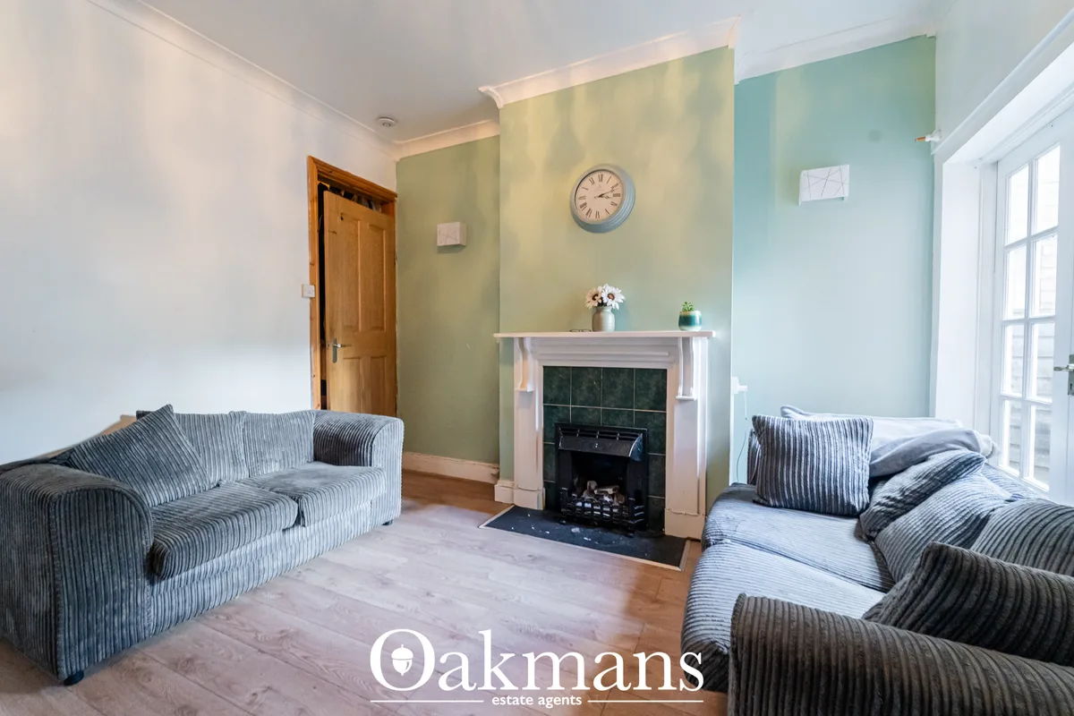 Bright living room with striped upholstered sofas, fireplace with cream surround, pale green and turquoise accent walls,