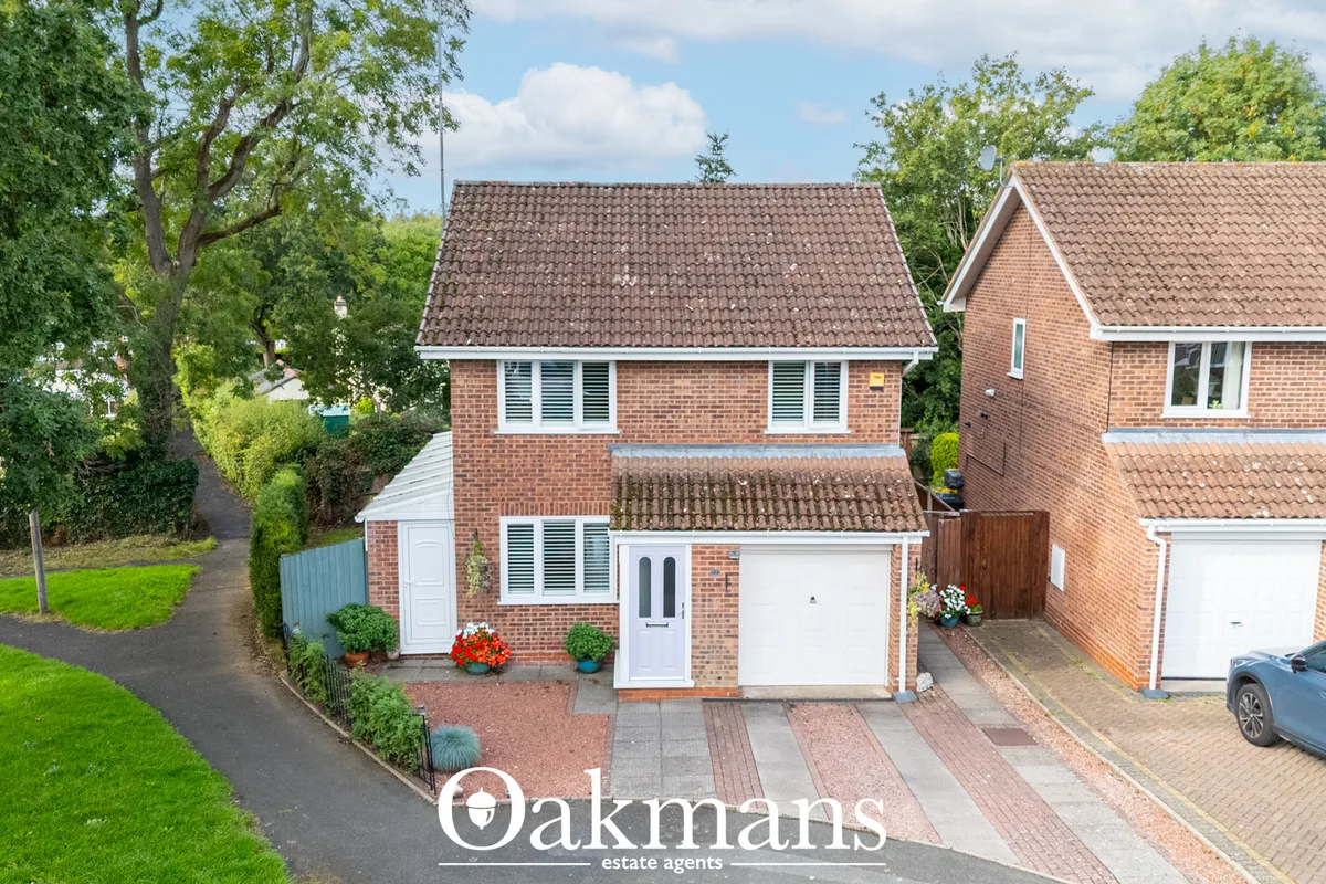 Two-storey brick detached house with tiled roof, white-framed windows, white garage door and red brick driveway, surroun