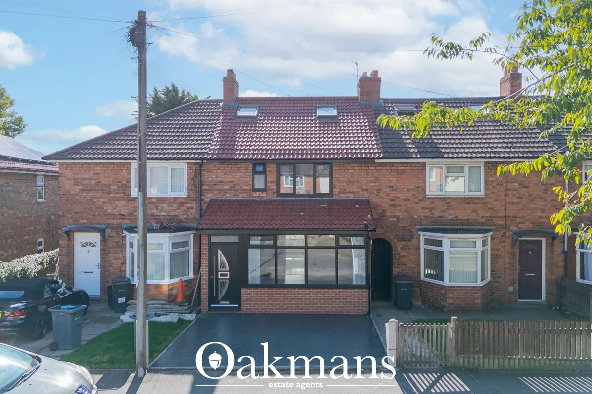 Brick-built semi-detached house with tiled roof, bay windows, black frames and driveway