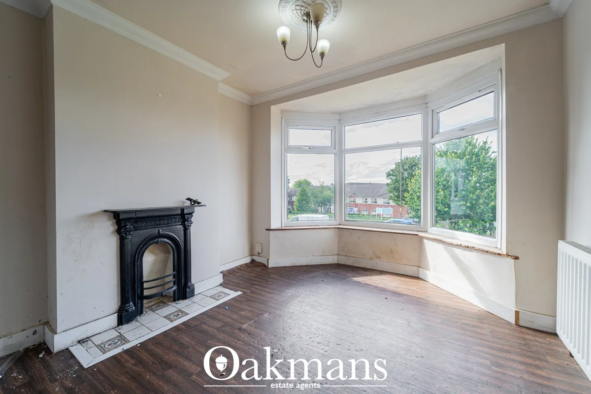 Bright living room with bay windows, black fireplace, wooden flooring, period ceiling rose and radiator