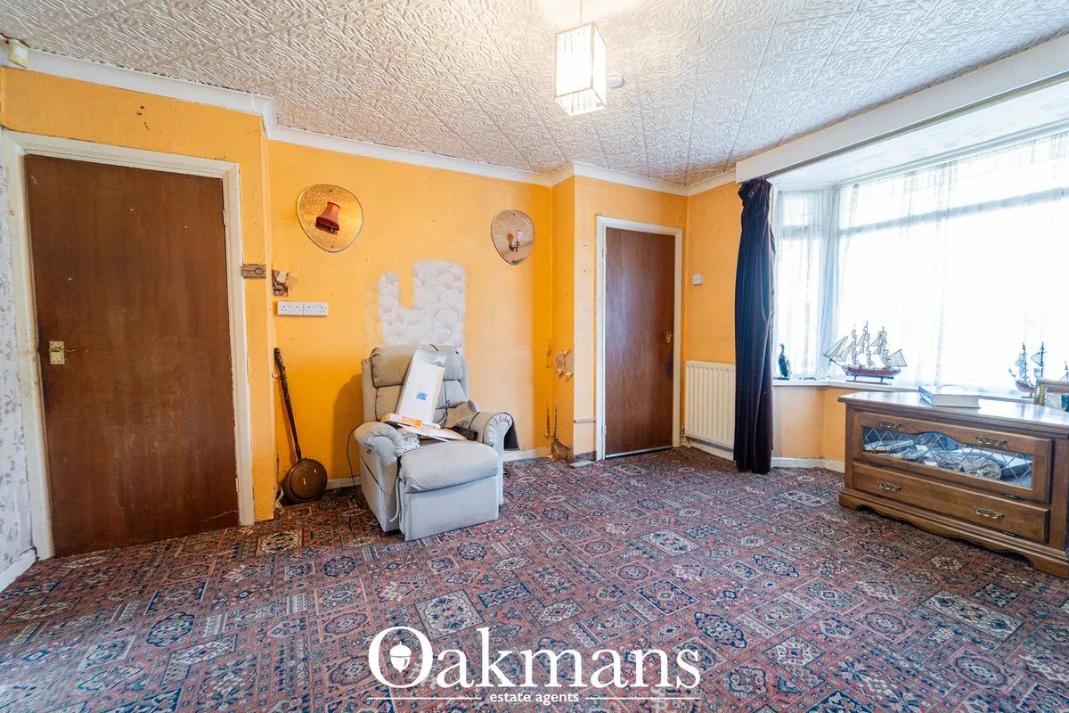 Spacious living room with bold yellow walls, patterned carpet, upholstered armchair, wooden furniture and maritime decor