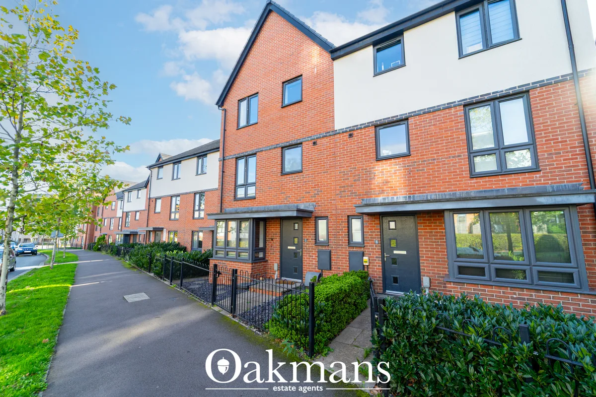 Modern brick residential development with contemporary townhouses, black metal railings, landscaped gardens and tree-lin