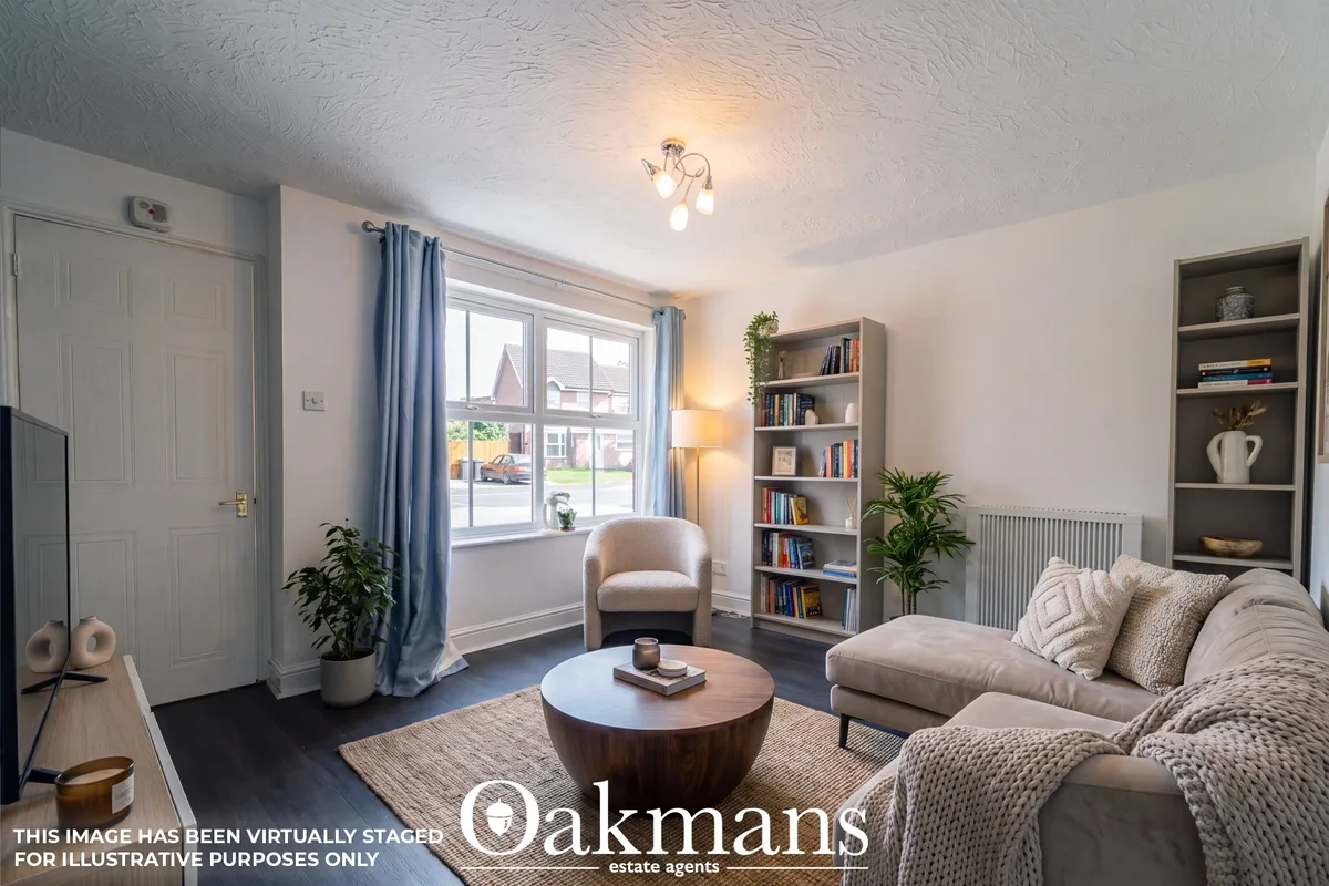 Neutral-toned living room with cream sofa, armchair, round wooden coffee table, built-in shelving, bay window with blue 