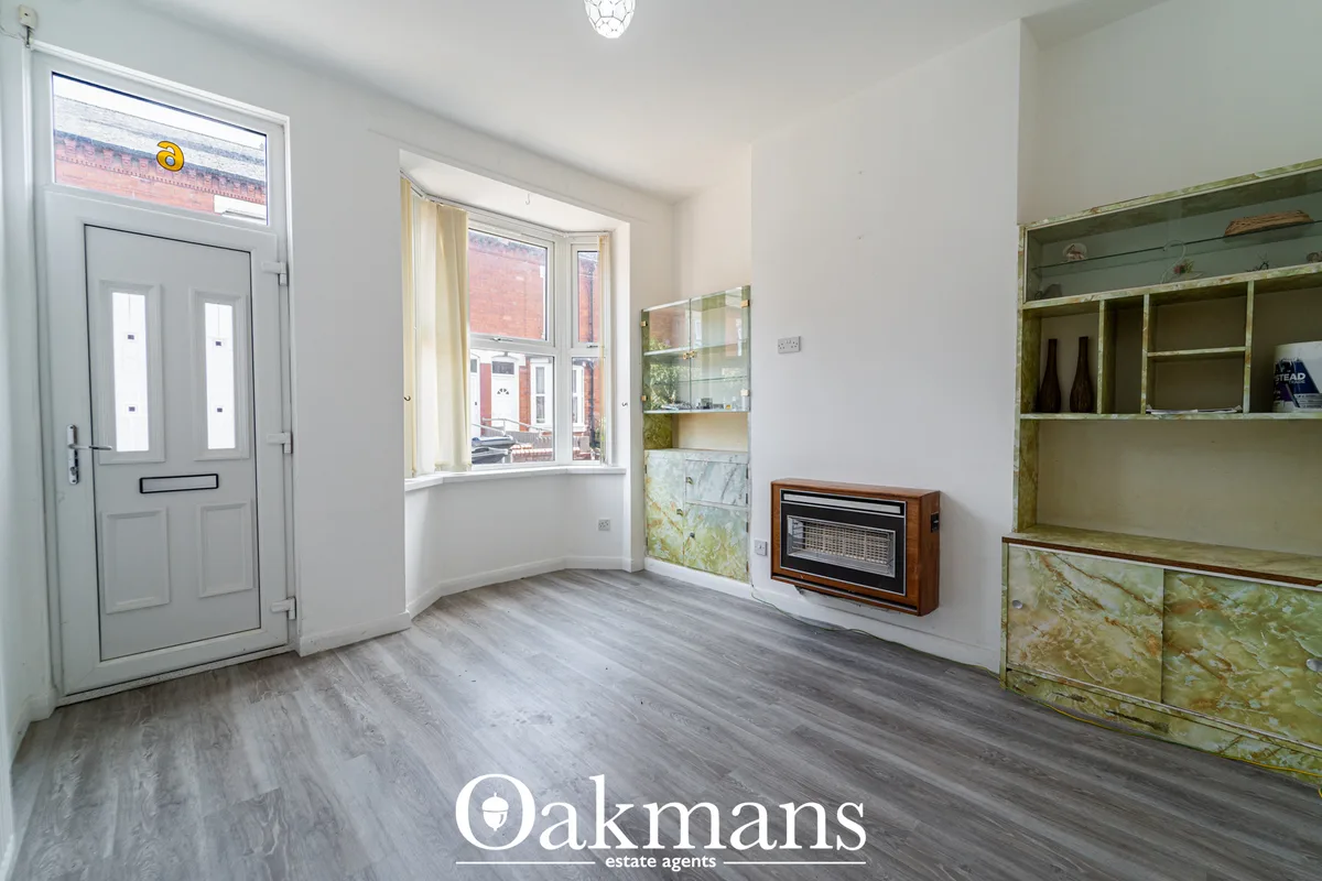 Bright entrance hallway with grey laminate flooring, white walls, glazed door with transom, bay window overlooking stree