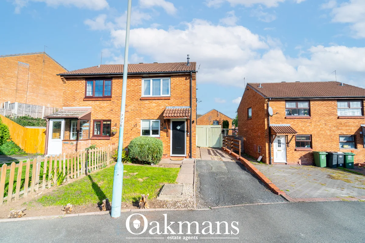 Brick-built semi-detached house with driveway, front garden and neighbouring properties on residential street
