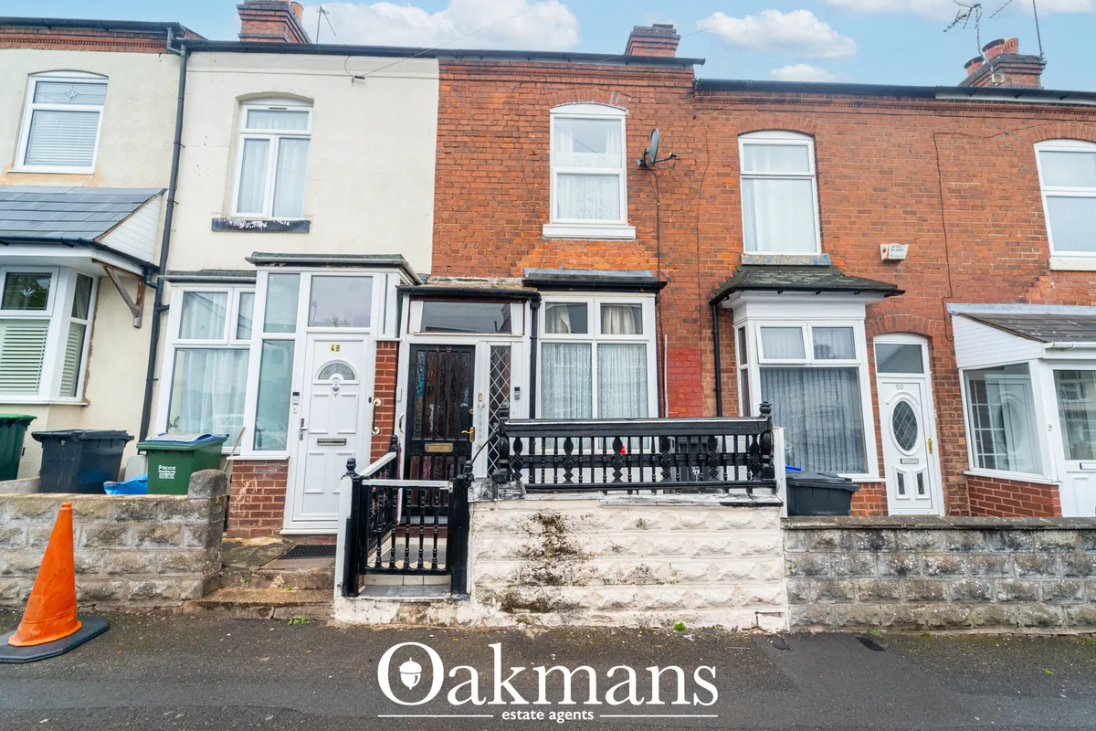 Terraced brick houses with red brick construction, white windows, black railings, and stone-faced forecourts